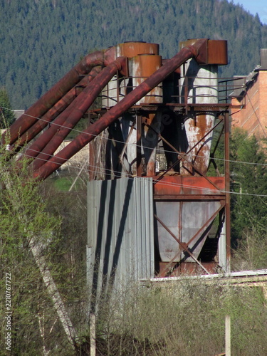 Old industrial cyclone dust collector system at furniture factory outdoor