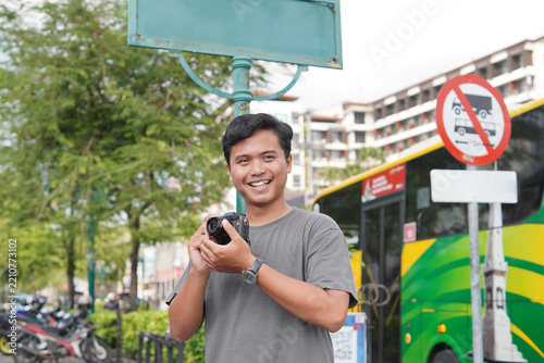 Asian Tourist Man Taking Photo with Camera Outdoors in Yogyakarta City