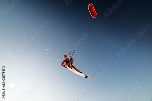 Kitesurfer Jumping High Against Clear Blue Sky