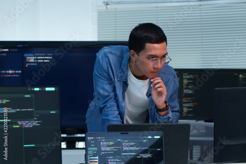 Programmer Analyzing Code on Multiple Screens