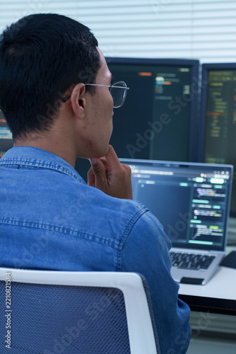 Programmer Analyzing Code on Multiple Screens