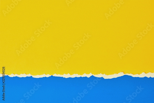 Yellow and blue torn paper background with ripped edge and copy space