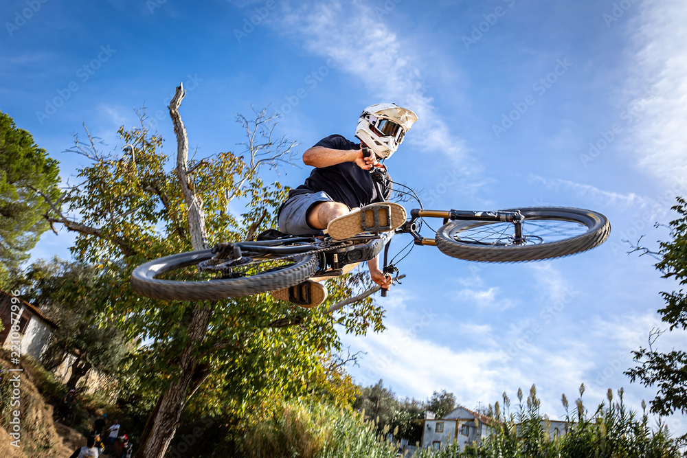 Obraz premium Dirt bike rider jumping on a dirt track in Arripiado village by the Tagus River, Portugal