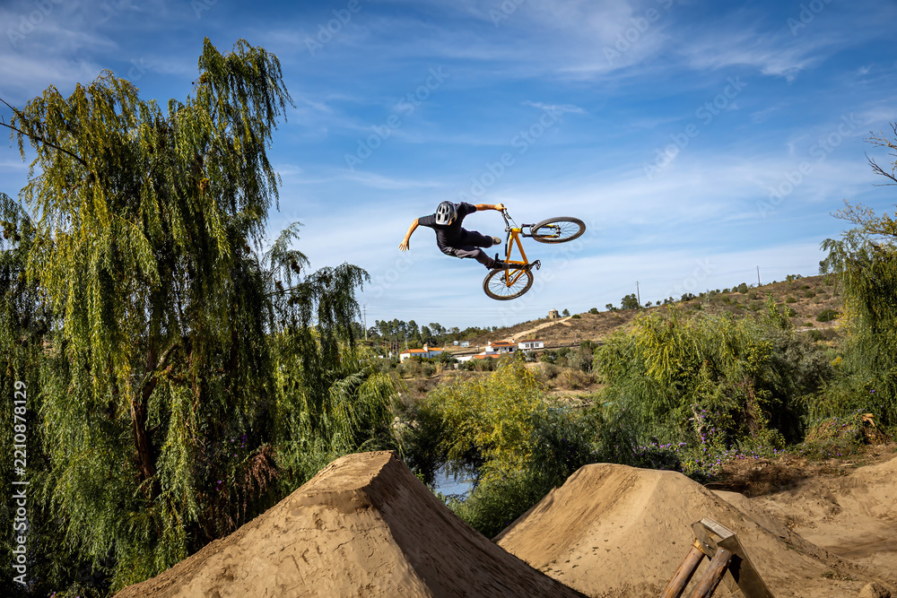 Obraz premium Dirt bike rider jumping on a dirt track in Arripiado village by the Tagus River, Portugal