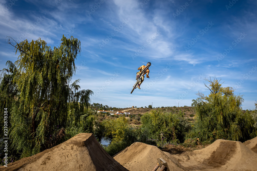 Obraz premium Dirt bike rider jumping on a dirt track in Arripiado village by the Tagus River, Portugal