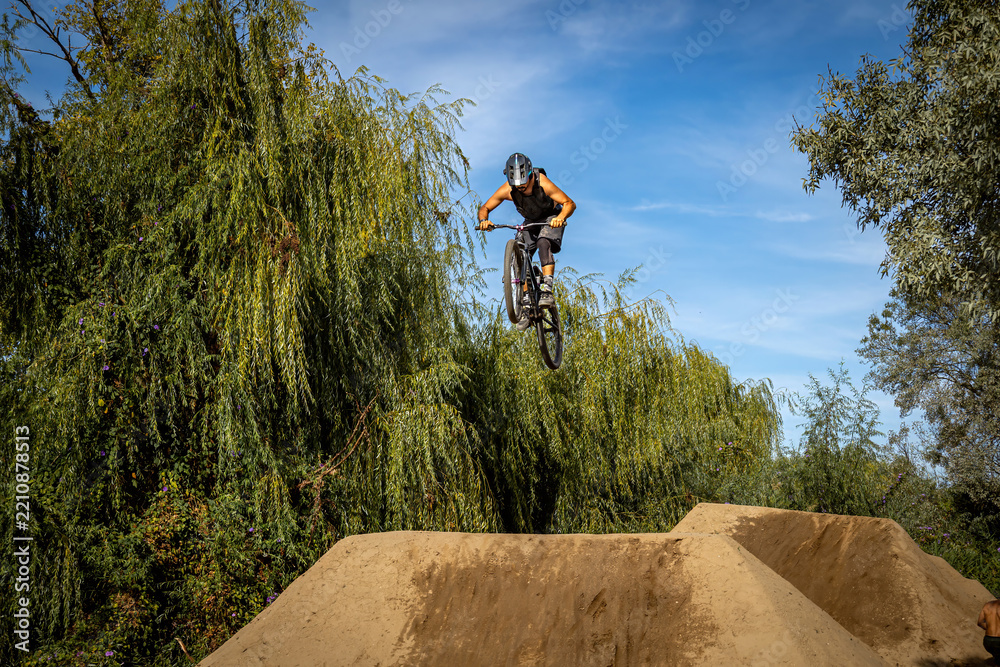 Obraz premium Dirt bike rider jumping on a dirt track in Arripiado village by the Tagus River, Portugal