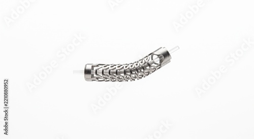 Macro of steerable intervention catheter tip. Micro-machined laser-cut stainless steel coil and quartz glass optical fiber. Minimally invasive medical hardware isolated on white background.