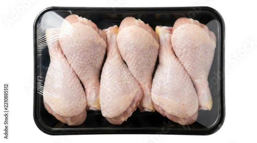 Raw chicken drumsticks in a black plastic tray isolated on transparent background