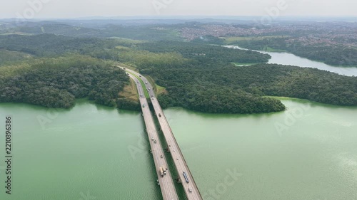 Aerial Reveal of Highway Bridge and Reservoir surrounded by Dense Forest