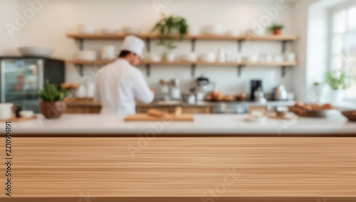 Empty brown wooden table top in focus, blurred bakery background. Modern bakery kitchen horizontal view with copy space for advertising product