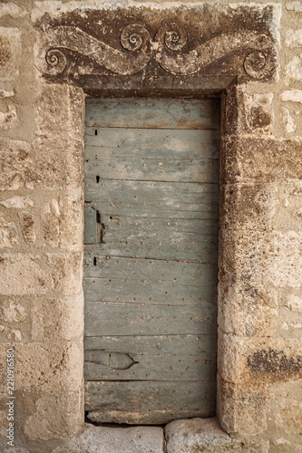 Verwitterte Holztür in einer historischen Hausfassade, Provence