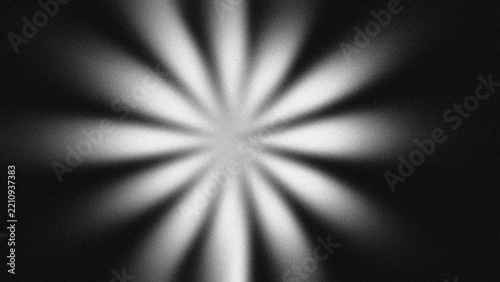 Abstract retro radial sunburst with monochrome grain texture. Dark starburst background, glowing light rays, vintage cinematic overlay.