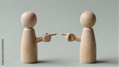 Two wooden figures point at each other, symbolizing conflict or accusation.