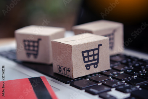 Shopping online. Credit card and cardboard box with a shopping cart logo on laptop keyboard. Shopping service on The online web. offers home delivery