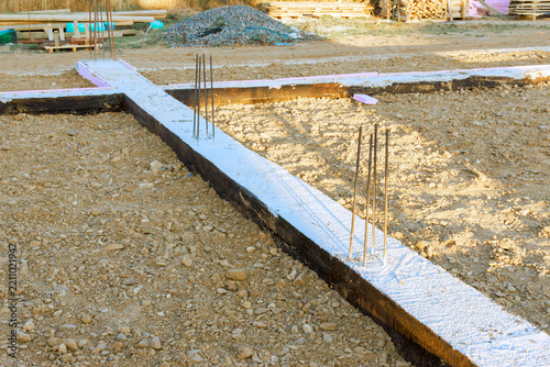 Workers prepare building foundation with rebar, concrete in construction site