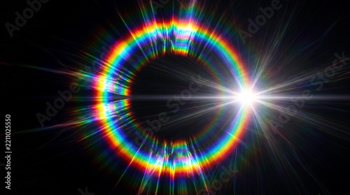 Abstract rainbow light circle glowing in the dark with bright lens flare and prismatic color spectrum refraction