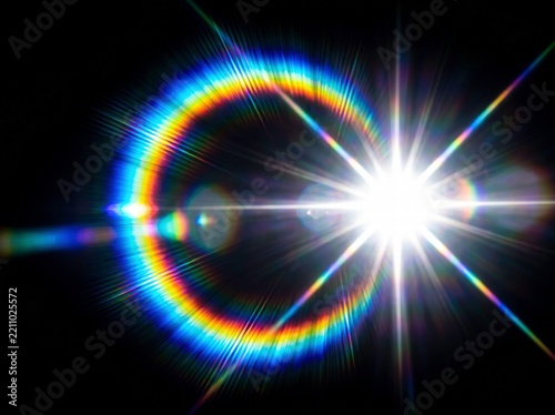 Bright lens flare with colorful rainbow halo and glowing light starburst on black background