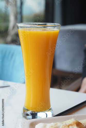 Fresh orange juice served in a tall glass at a cafe