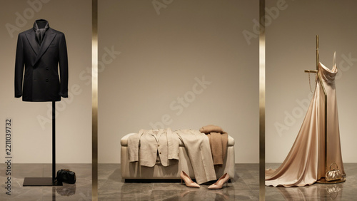 Fashion display featuring a suit on a mannequin and a flowing dress on a stand in a studio
