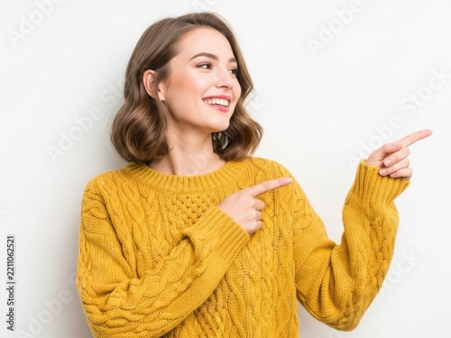 Smiling woman pointing finger happily