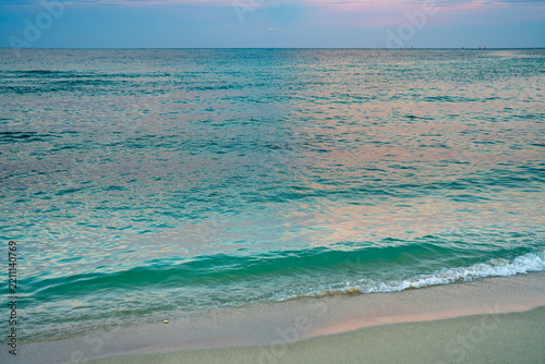 Atmospheric sunrise colors enrich ocean landscape. Atmospheric clouds deepen the coastal mood. Romantic atmospheric light warms turquoise water. Soft atmospheric colors define dreamlike seascape.