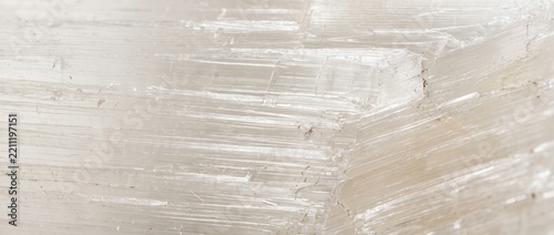 Macro close-up of translucent selenite crystal showing fibrous texture and horizontal striations