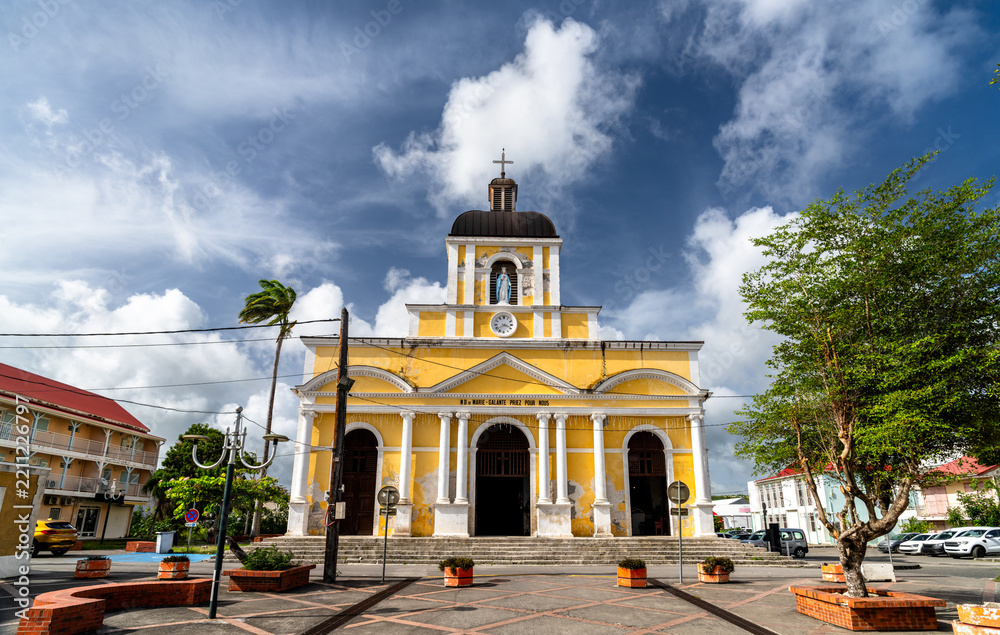 Fototapeta premium Facade of the Notre-Dame-de-l'Assomption church under a cloudy sky in Grand-Bourg, Marie-Galante Island, Guadeloupe, Caribbean France