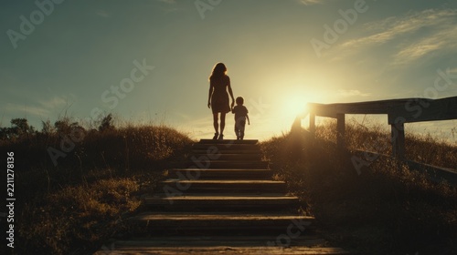 Mother and child walking up stairs at sunset by the water