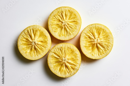 Dried lemon slices arranged in a diamond pattern on a white background in a sharp macro shot for culinary branding and health food marketing