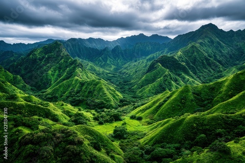 Lush green mountains with sharp ridges and deep valleys under a moody overcast sky in a cinematic landscape shot for travel and nature branding