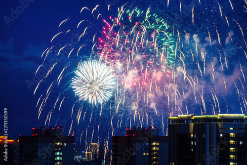 Bright golden fireworks bursting in dark blue night sky above a building. Vibrant celebration for holiday, festival, and New Year events
