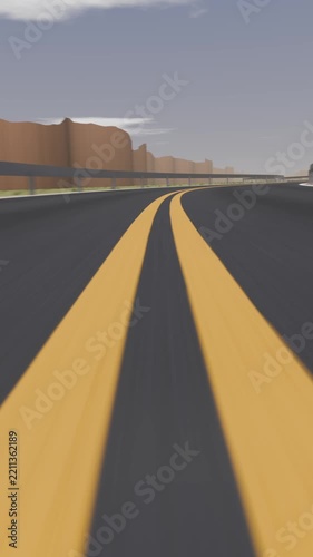 Vertical video: Moving low camera following double yellow lines through canyon road
