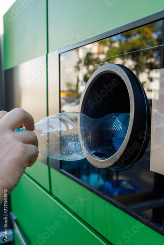 Person inserting plastic bottle into recycling collection machine