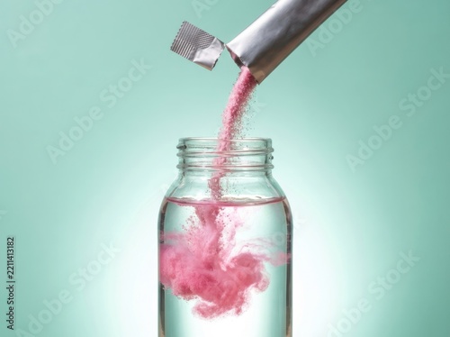 Beverage formulation pink powder dissolving in glass jar