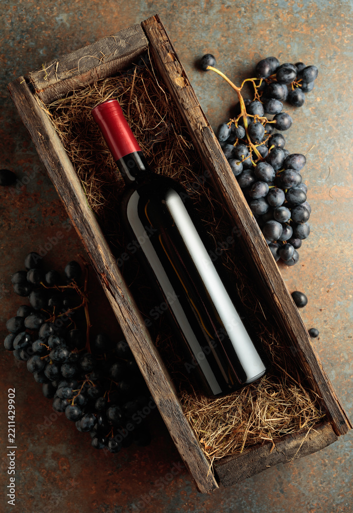Obraz premium Bottle of red wine in an antique wooden box.