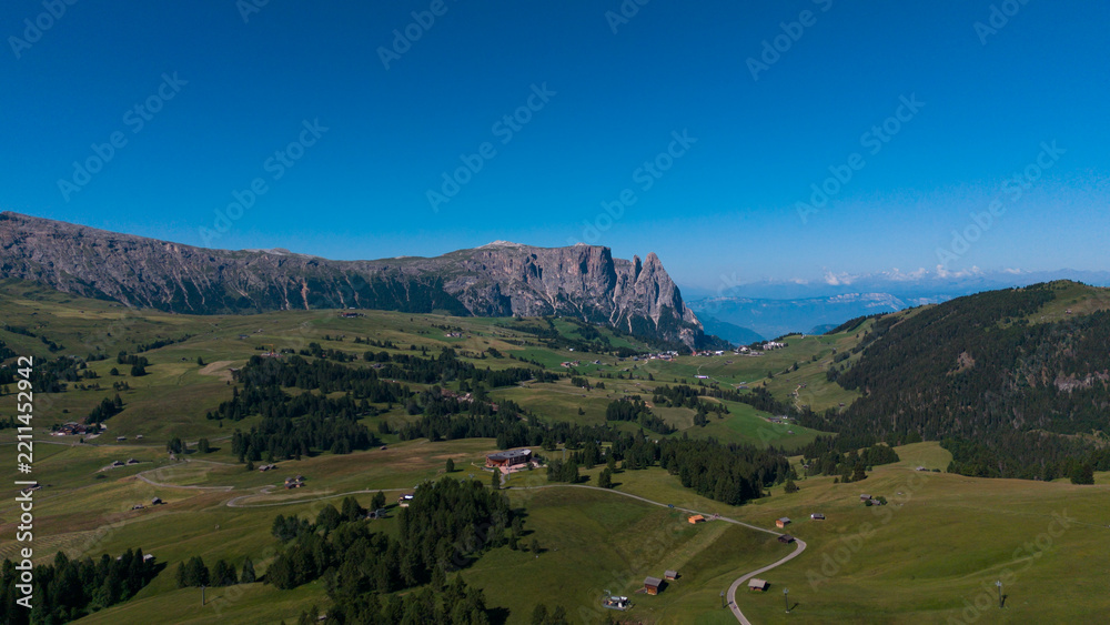 Obraz premium View of beautiful landscape in the Alps with fresh green meadows in the background on a sunny day with blue sky and clouds in summertime. Alpe de Siusi, Dolomite Alps