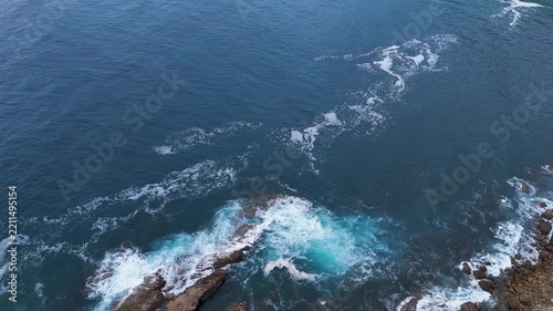 Aerial view of the Atlantic ocean waves crashing on the rocky coast of Asturias