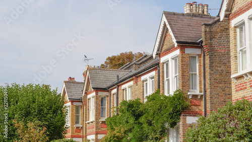 Fotografie A row of traditional English brick houses with tiled roofs, chimneys, bay window