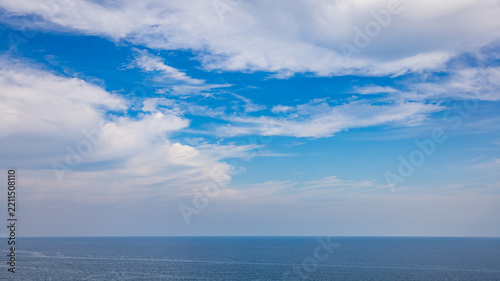 Vivid Blue Sky and Open Ocean Horizon with Sweeping White Clouds and Copy Space for Design
