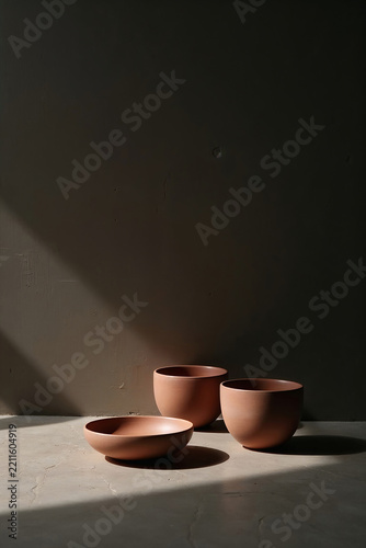 Minimalist terracotta ceramic bowls on concrete surface for tea ceremony