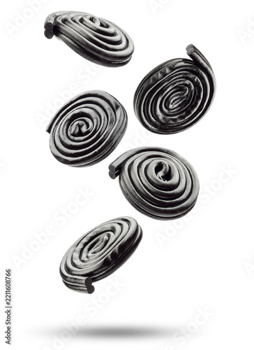 Liquorice candy wheels flying, isolated on white background.