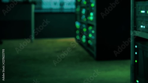 A dimly lit data center showcases rows of servers, emitting a soft green light. The atmosphere feels both futuristic and calm, highlighting the importance of technology in our lives.