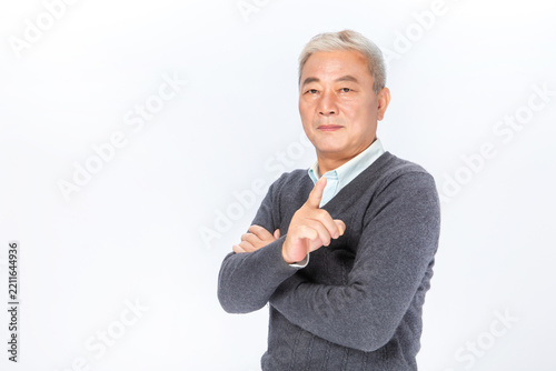 Senior Asian man pointing finger in warning or instructive gesture on white background