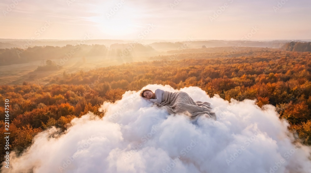 Fototapeta premium Woman sleeping peacefully on fluffy cloud above golden autumn forest