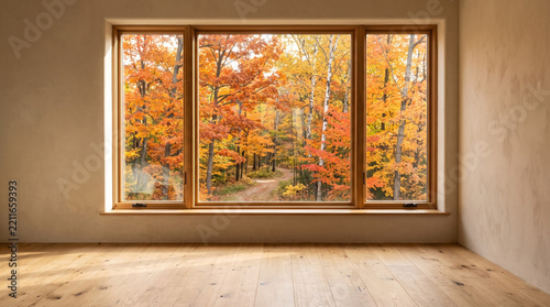 Cozy home interior with a large window showcasing a vibrant autumn forest landscape with colorful trees and a winding path during the day