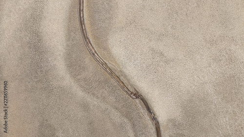 Aerial view of a completely dry river bed cutting through a parched landscape, highlighting the effects of prolonged drought and severe water scarcity in Bloemhof, North West, South Africa.