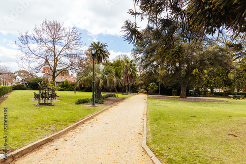 Path through St Arnaud park with trees and historic architecture in background