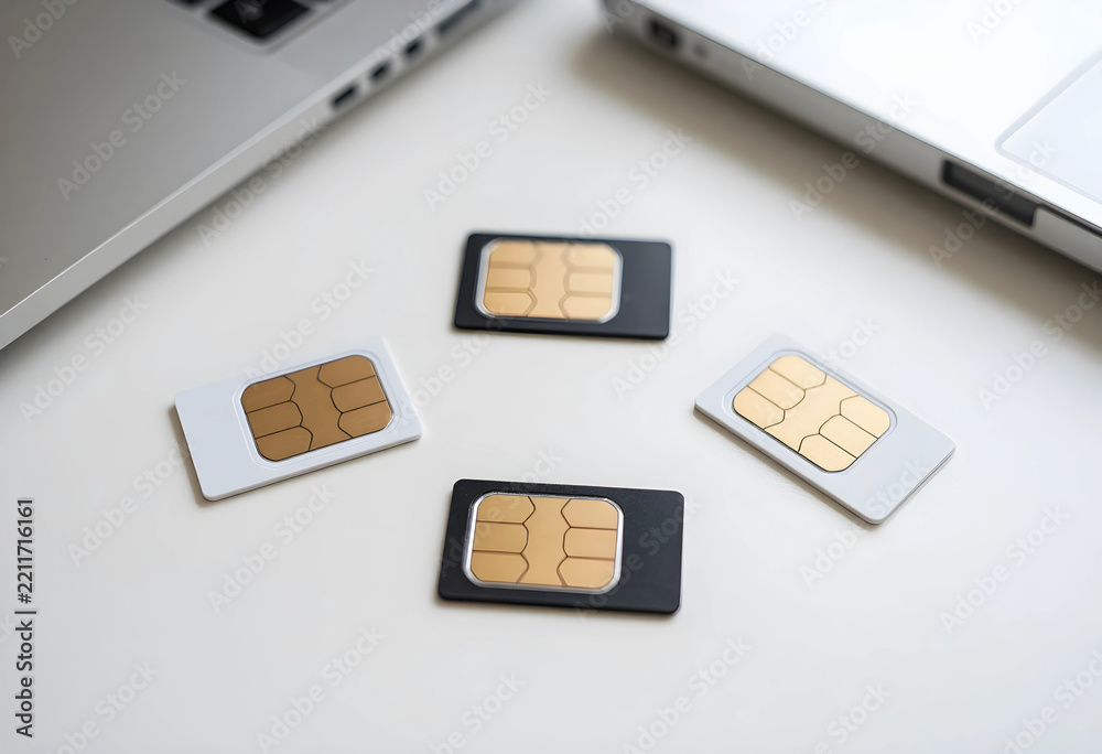 Fototapeta premium Mobile connectivity and global roaming, sim cards for cellular network access and digital communication on a desk with laptops for business technology