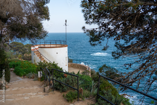 White scenic viewpoint tower overlooking the blue Mediterranean Sea in Marimurtra Botanical Garden, Blanes, Costa Brava, Spain. Beautiful coastal landscape and travel destination.