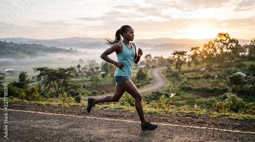 female athlete running on rural road during sunrise or sunset
